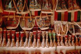 Image du Maroc Professionnelle de  Dans un bazar au souk Semmarine à Marrakech des bottes, babouches et sac réalisés grâce à un mélange artisanale de tissages ressemblant au kilim et de cuir, ces produits principalement destinés aux touristes en très peu de temps sont devenu très à la mode au tourismes interne, Jeudi 19 Mai 1988. (Photo / Abdeljalil Bounhar) 